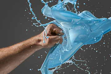 Image showing Close-up of a man\'s fist punching through liquid