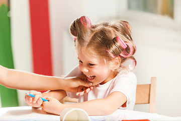 Image showing The young mother and her little daughter drawing with pencils at home