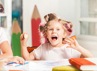 Image showing The young mother and her little daughter drawing with pencils at home