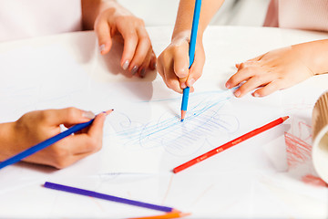 Image showing The young mother and her little daughter drawing with pencils at home