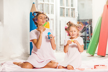 Image showing Little girl sitting with her mother and playing