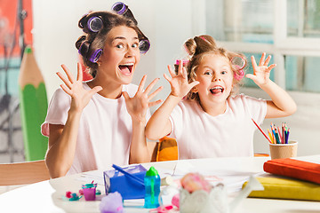 Image showing The young mother and her little daughter drawing with pencils at home