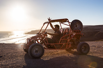 Image showing Man driving quadbike in sunset.