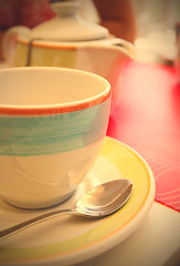 Image showing tea cup with a spoon of sugar on table