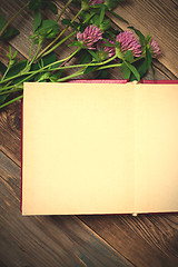 Image showing Top view of open book photo album with clover flowers