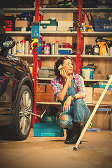 Image showing mechanic in an auto repair shop talking on mobile