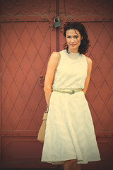 Image showing woman in a white dress near the old metal gate