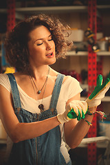 Image showing worker of a car repair shop dressing protective gloves and sings