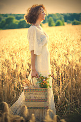 Image showing Woman Outdoors with wicker bag with natural meal 