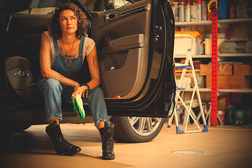 Image showing Portrait of a handsome mechanic in blue overalls on the threshol