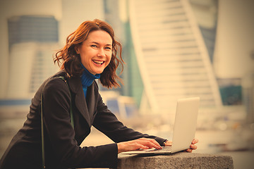 Image showing portrait of a beautiful laughing woman with a laptop