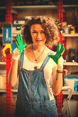 Image showing mechanic woman with work gloves on her hands in car repair works