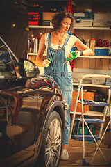 Image showing mechanic woman working on a car in an auto repair shop