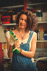 Image showing smiling woman mechanic in blue denim overalls tries to hand prot