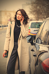 Image showing fashion. beautiful woman in a bright coat talking on the mobile