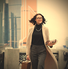 Image showing smiling middle aged brunette in the business district of the cit