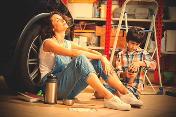 Image showing resting mechanic woman and boy with thermos