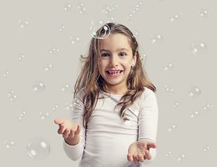 Image showing Girl playing with soap bubbles