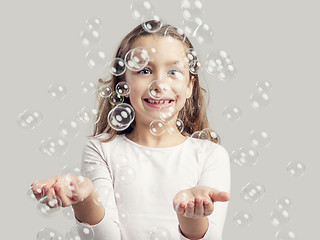 Image showing Girl playing with soap bubbles