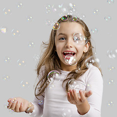 Image showing Girl playing with soap bubbles