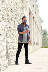 Image showing man texting message with smartphone on city street