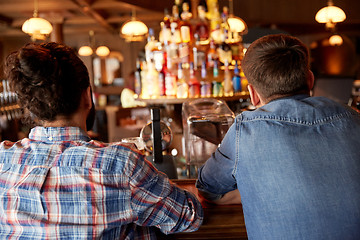 Image showing close up of male friends at bar counter in pub