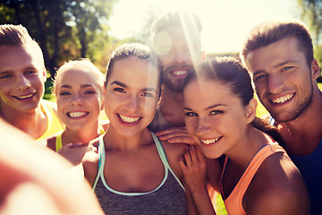 Image showing happy friends taking selfie with smartphone