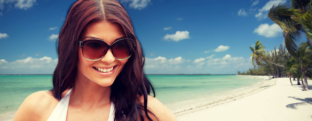 Image showing smiling young woman with sunglasses on beach