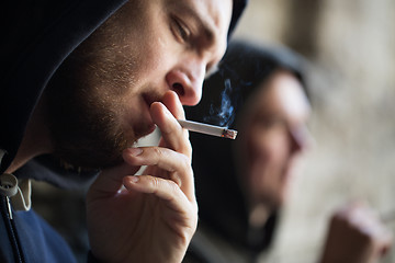 Image showing close up of young man smoking cigarette outdoors