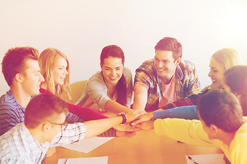 Image showing group of smiling students with hand on top