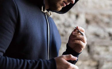 Image showing close up of addict lighting up marijuana joint