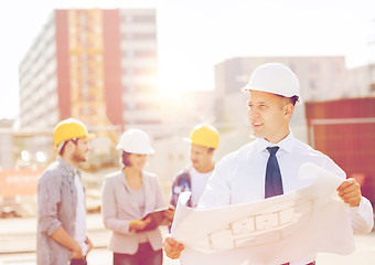 Image showing group of builders with tablet pc and blueprint