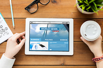 Image showing close up of woman with tablet pc on wooden table