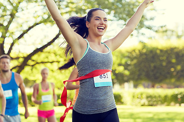 Image showing happy young female runner winning on race finish