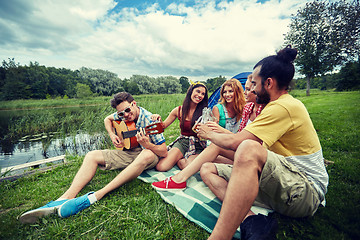 Image showing happy friends with drinks and guitar at camping