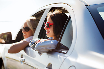 Image showing happy teenage girls or women in car at seaside