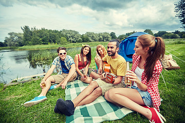 Image showing happy friends with drinks and guitar at camping