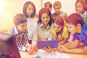 Image showing group of kids with teacher and tablet pc at school