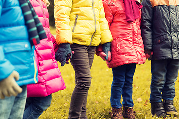 Image showing close up of children holding hands in autumn park