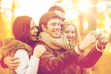 Image showing group of friends with photo camera in autumn park