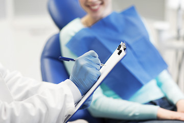 Image showing close up of dentist with clipboard and patient