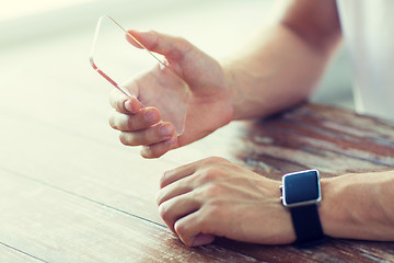 Image showing close up of hands with smart phone and watch