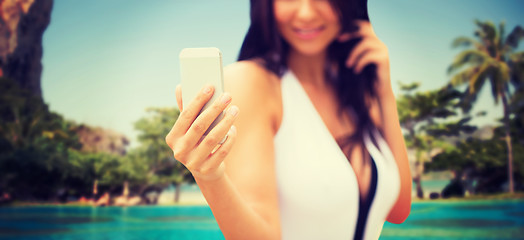 Image showing young woman taking selfie with smartphone on beach