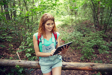 Image showing happy woman with backpack and tablet pc in woods