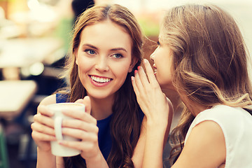 Image showing young women drinking coffee and talking at cafe