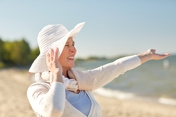 Image showing happy senior woman in sun hat on summer beach