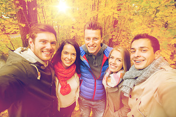 Image showing group of smiling men and women in autumn park