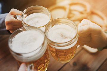 Image showing close up of hands with beer mugs at bar or pub