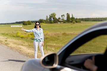 Image showing woman hitchhiking and stopping car at countryside