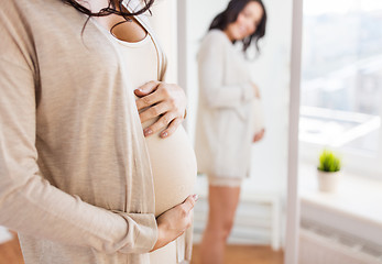 Image showing close up of pregnant woman looking to mirror